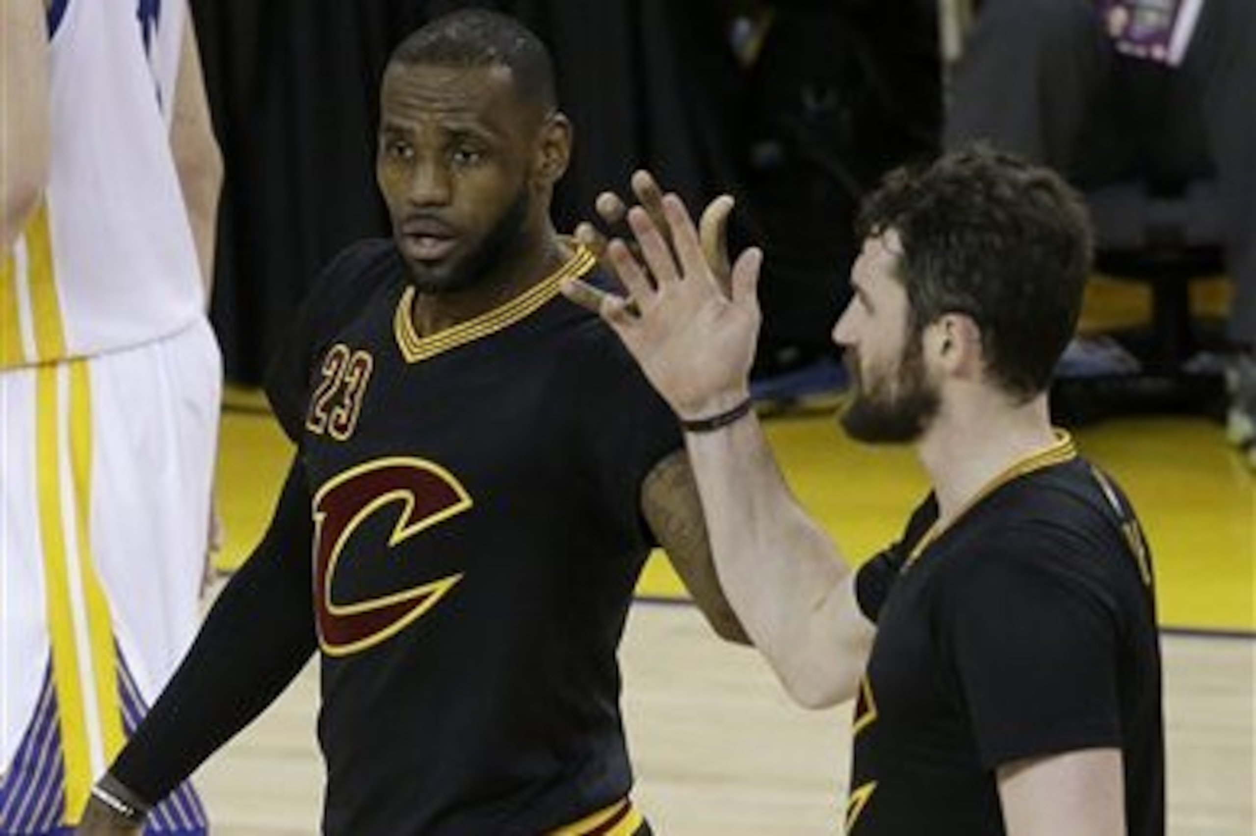 Cleveland Cavaliers forward LeBron James (23) and forward Kevin Love react during the second half of Game 5 of basketball's NBA Finals against the Golden State Warriors in Oakland, Calif., Monday, June 13, 2016. (AP Photo/Marcio Jose Sanchez)