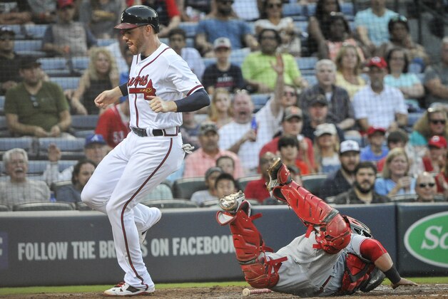 Atlanta Braves' Freddie Freeman scores on a Jace Peterson ground ball to third base as Cincinnati Reds catcher Ramon Cabrera dives to attempt a tag during the third inning of a baseball game, Wednesday, June 15, 2016, in Atlanta. (AP Photo/John Amis)