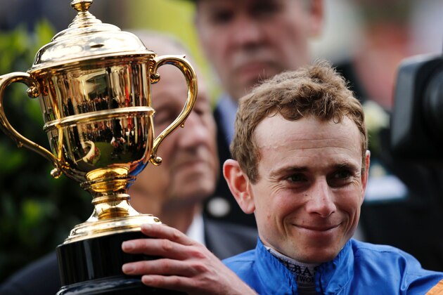 Jockey Ryan Moore lifts the Gold Cup in Honour of The Queen's 90th Birthday after riding Order of St George to win the main race during Ladies' day at Royal Ascot horse racing meet in Ascot, west of London on June 16, 2016. 

The five-day meeting is one of the highlights of the horse racing calendar. Horse racing has been held at the famous Berkshire course since 1711 and tradition is a hallmark of the meeting. Top hats and tails remain compulsory in parts of the course while a daily procession of horse-drawn carriages brings the Queen to the course.  / AFP / ADRIAN DENNIS        (Photo credit should read ADRIAN DENNIS/AFP/Getty Images)
