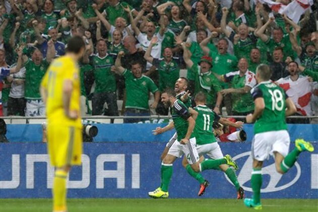 Northern Ireland's Gareth Mcauley, center left, celebrates after scoring the opening goal during the Euro 2016 Group C soccer match between Ukraine and Northern Ireland at the Grand Stade in Decines-­Charpieu, near Lyon, France, Thursday, June 16, 2016. (AP Photo/Pavel Golovkin)