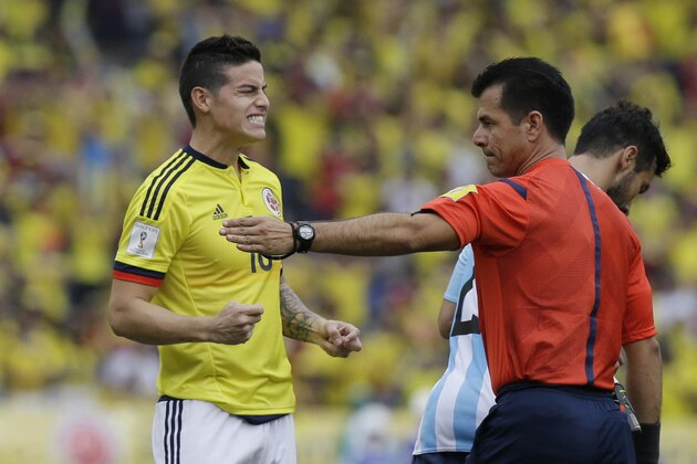 Colombia's James Rodríguez gestures next to referee Carlos Vera, of Ecuadro, during a 2018 World Cup qualifying soccer match against Argentina in Barranquilla, Colombia, Tuesday, Nov. 17, 2015. (AP Photo/Fernando Vergara)