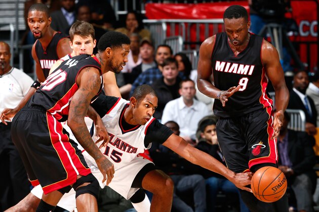 ATLANTA, GA - NOVEMBER 14:  Al Horford #15 of the Atlanta Hawks reaches for a steal between Udonis Haslem #40 and Luol Deng #9 of the Miami Heat at Philips Arena on November 14, 2014 in Atlanta, Georgia.  NOTE TO USER: User expressly acknowledges and agrees that, by downloading and or using this photograph, User is consenting to the terms and conditions of the Getty Images License Agreement.  (Photo by Kevin C. Cox/Getty Images)