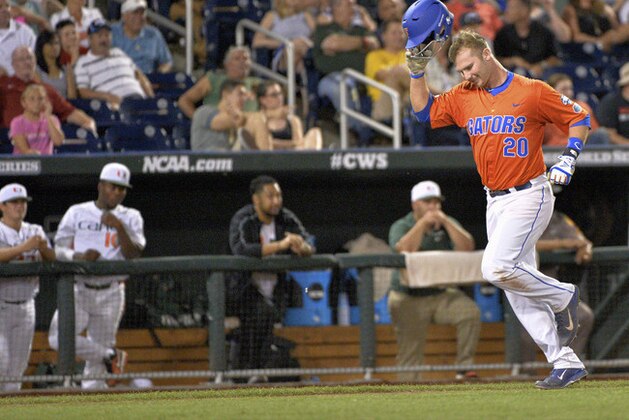 Florida first baseman Peter Alonso (20) runs past the Miami dugout while running the bases on a two-run home run in the seventh inning of an NCAA College World Series baseball elimination game at TD Ameritrade Park in Omaha, Neb., Wednesday, June 17, 2015. (AP Photo/Ted Kirk)