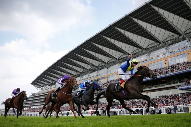 Jockey Frankie Dettori (R) celebrates as he crosses the finishing post riding Across The Stars to win The King Edward VII Stakes group 2 race during day four at Royal Ascot horse racing meet, in Ascot, west of London, on June 17, 2016. 
The five-day meeting is one of the highlights of the horse racing calendar. Horse racing has been held at the famous Berkshire course since 1711 and tradition is a hallmark of the meeting. Top hats and tails remain compulsory in parts of the course while a daily procession of horse-drawn carriages brings the Queen to the course.  / AFP / ADRIAN DENNIS        (Photo credit should read ADRIAN DENNIS/AFP/Getty Images)
