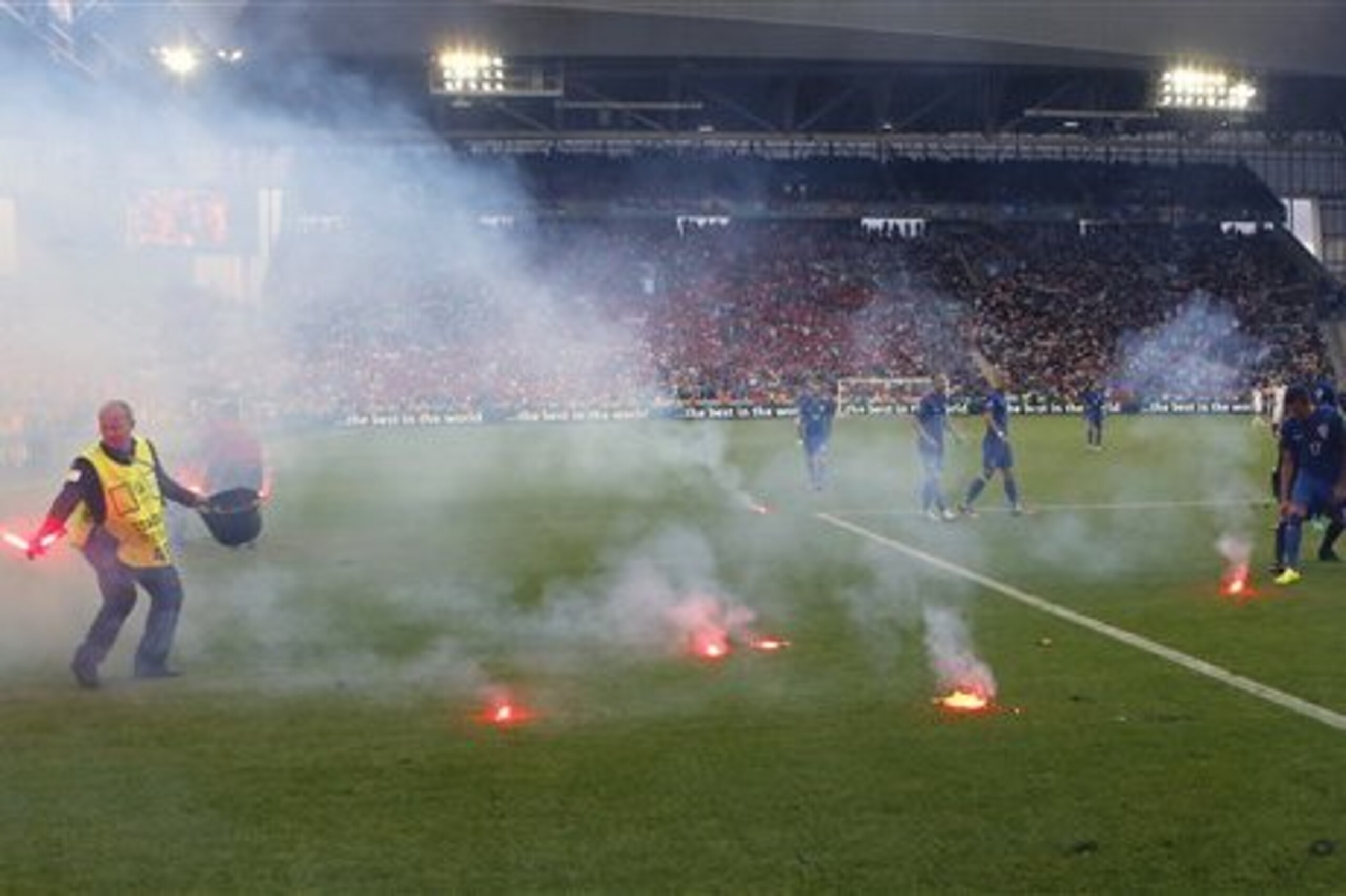 Flares are thrown onto the pitch during the Euro 2016 Group D soccer match between the Czech Republic and Croatia at the Geoffroy Guichard stadium in Saint-Etienne, France, Friday, June 17, 2016. Czech Republic salvaged a 2-2 draw with Croatia in a game marred by a temporary suspension when flares were thrown onto the pitch and Croatia fans fought among themselves. (AP Photo/Darko Bandic)