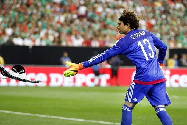 Mexico's goalie Guillermo Ochoa tosses a sombrero off the field after it was thrown from the stands by a spectator during the first half of an exhibition soccer game against Paraguay, Saturday, May 28, 2016, in Atlanta. (AP Photo/John Bazemore)