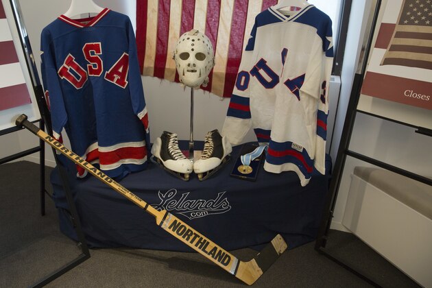 A display featuring 1980 U.S. Winter Olympics hockey goalie Jim Craig's Olympic gold medal, the jerseys, the hockey skates, and goalie equipment he wore in the Soviet and Finland games and the iconic American flag that was draped over his shoulders after the gold medal win, are displayed during a news conference, Tuesday, May 24, 2016, in New York. Craig, the hockey goaltender who helped the U.S. win a miraculous gold medal at the 1980 winter Olympics, is auctioning off the items. (AP Photo/Mary Altaffer)