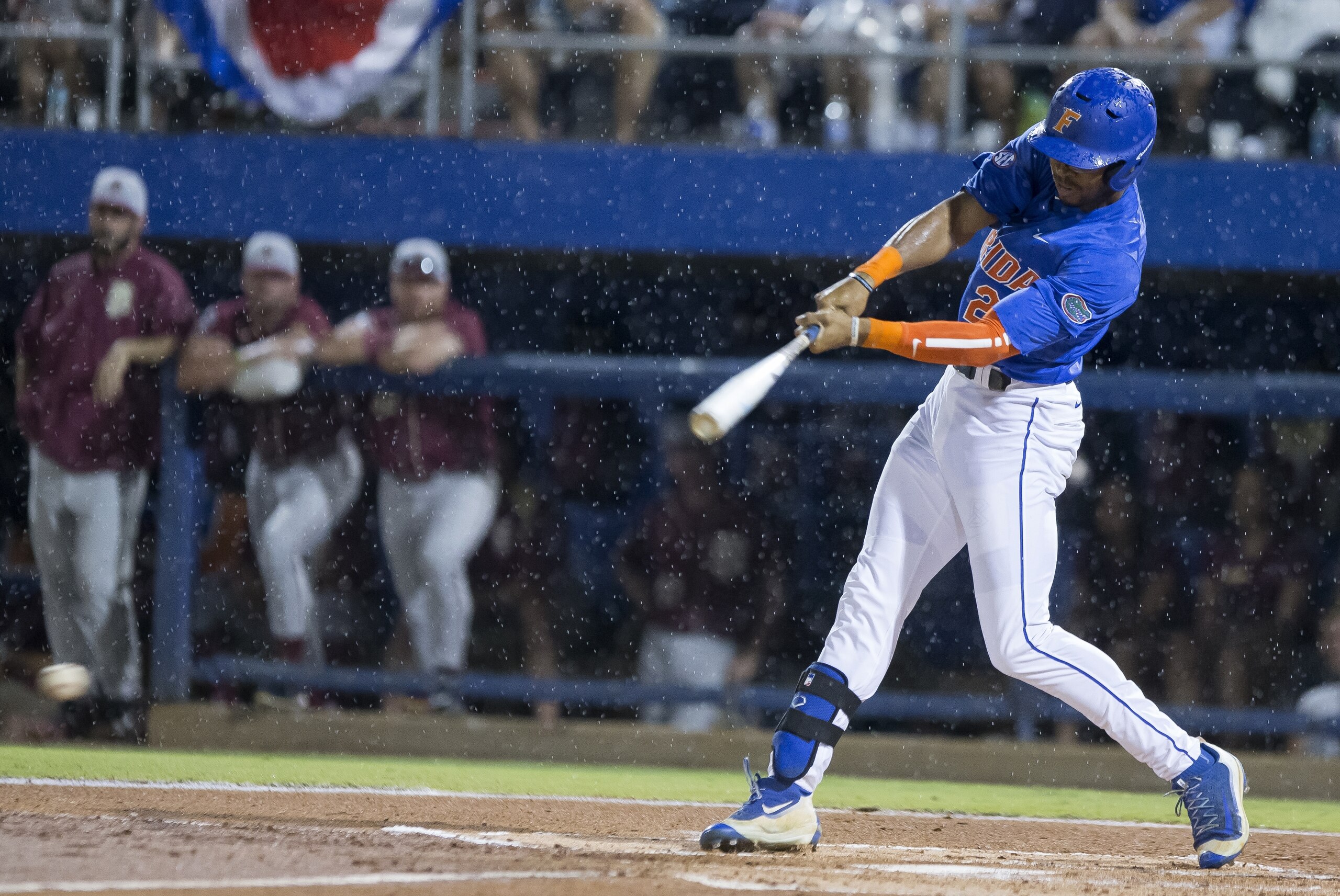 Florida's Buddy Reed (23) hits a ground ball in the rain against Florida State in Game 3 of NCAA college baseball tournament super regional in Gainesville, Fla., on Monday, June 13, 2016.  Florida won 7-0. (AP Photo/Ronald Irby)