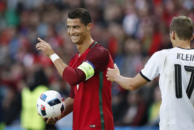 Portugal's Cristiano Ronaldo smiles as he holds the ball during the Euro 2016 Group F soccer match between Portugal and Austria at the Parc des Princes stadium in Paris, France, Saturday, June 18, 2016. (AP Photo/Christophe Ena)