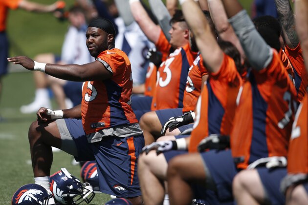 Denver Broncos tackle Russell Okung, left, stretches with teammates during an NFL football practice at the team's headquarters Wednesday, June 8, 2016, in Englewood, Colo. (AP Photo/David Zalubowski)