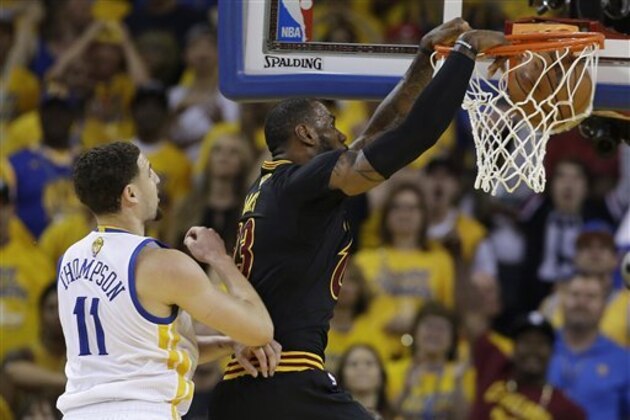 Cleveland Cavaliers forward LeBron James, right, dunks in front of Golden State Warriors guard Klay Thompson (11) during the first half of Game 7 of basketball's NBA Finals in Oakland, Calif., Sunday, June 19, 2016. (AP Photo/Marcio Jose Sanchez)