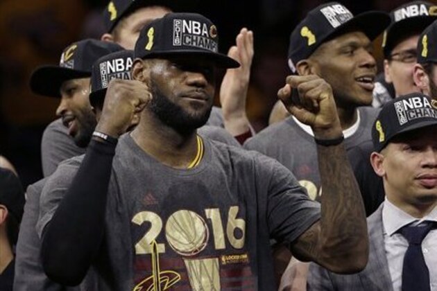 Cleveland Cavaliers forward LeBron James, left, celebrates with head coach Tyronn Lue, right, and teammates after Game 7 of basketball's NBA Finals against the Golden State Warriors in Oakland, Calif., Sunday, June 19, 2016. The Cavaliers won 93-89. (AP Photo/Marcio Jose Sanchez)