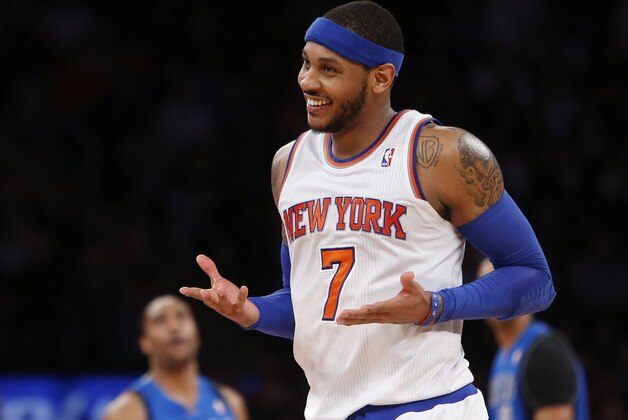 FILE - In this Feb. 24, 2014, file photo, New York Knicks' Carmelo Anthony (7) smiles after hitting a 3-point shot against the Dallas Mavericks during an NBA basketball gam in New York. Anthony is remaining with the Knicks, saying he wants
