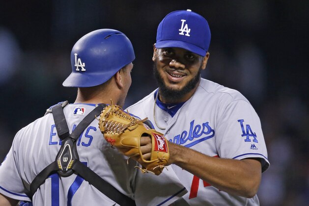 Los Angeles Dodgers' Kenley Jansen, right, smiles as he hugs catcher A.J. Ellis, left, after the final out against the Arizona Diamondbacks in the ninth inning of a baseball game Wednesday, June 15, 2016, in Phoenix. The Dodgers defeated the Diamondbacks 3-2. (AP Photo/Ross D. Franklin)