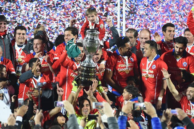 Chilean players celebrate with the trophy of the 2015 Copa America football championship, in Santiago, Chile, on July 4, 2015.    AFP PHOTO / PABLO PORCIUNCULA        (Photo credit should read PABLO PORCIUNCULA/AFP/Getty Images)