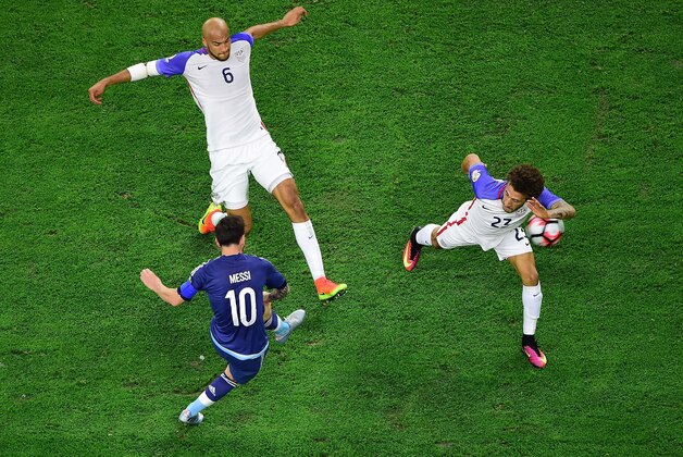 Argentina's Lionel Messi (10) passes the ball between USA's John Brooks and Fabian Johnson (R) during their Copa America Centenario semifinal football match in Houston, Texas, United States, on June 21, 2016.  / AFP / Frederic J. BROWN        (Photo credit should read FREDERIC J. BROWN/AFP/Getty Images)