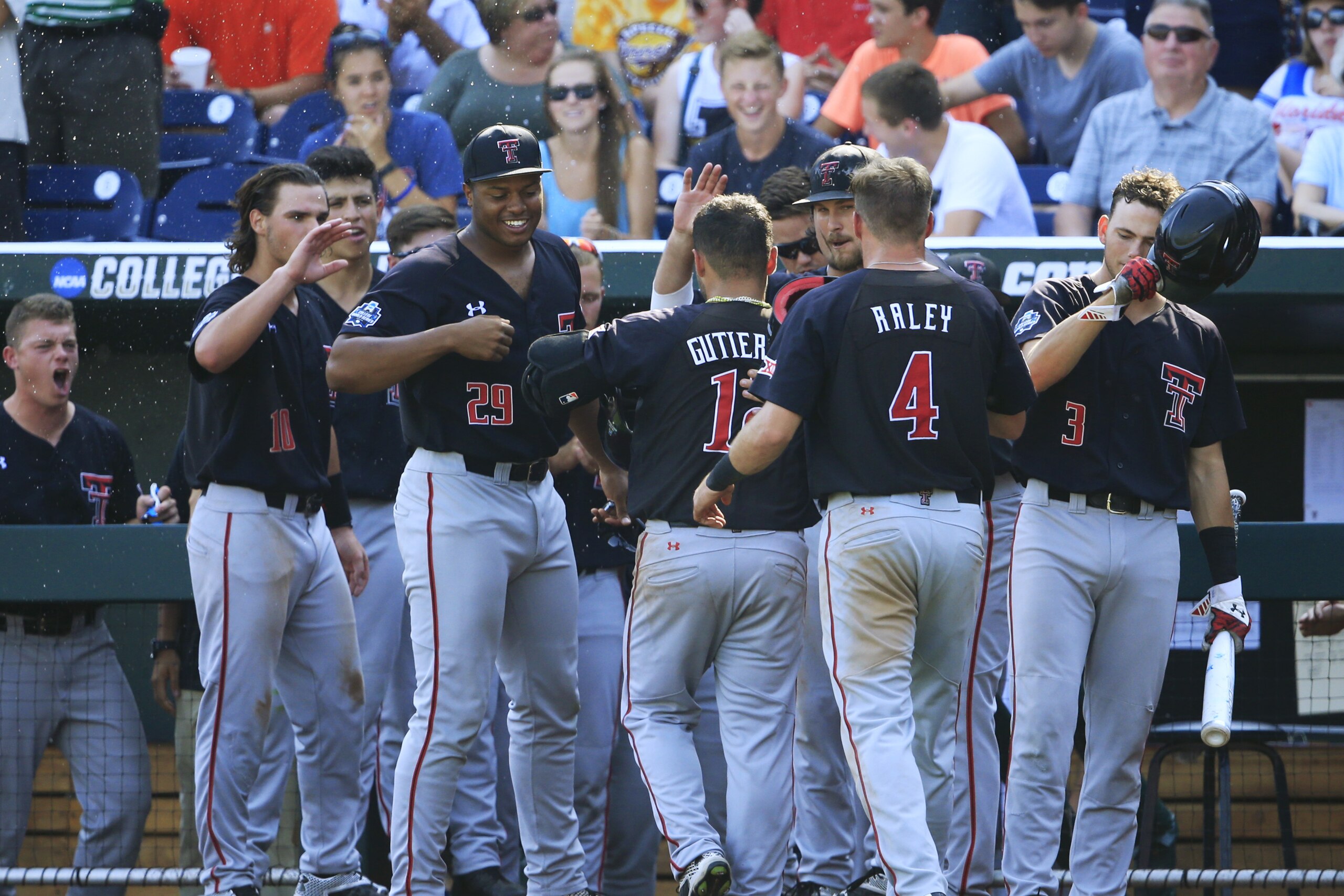 Texas Tech's Eric Gutierrez (12) is congratulated by his teammates after hitting a two-run home run against Florida in the fourth inning of an NCAA men's College World Series baseball game, Tuesday, June 21, 2016, in Omaha, Neb. (AP Photo/Nati Harnik)
