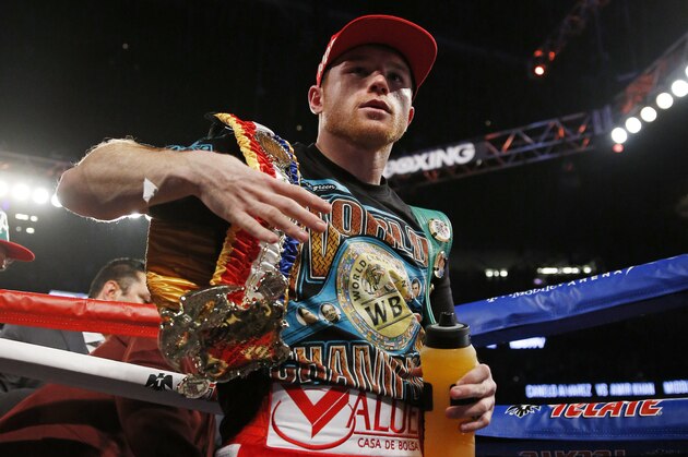Canelo Alvarez holds his belts after defeating Amir Khan during their WBC middleweight title fight Saturday, May 7, 2016, in Las Vegas. (AP Photo/Isaac Brekken)