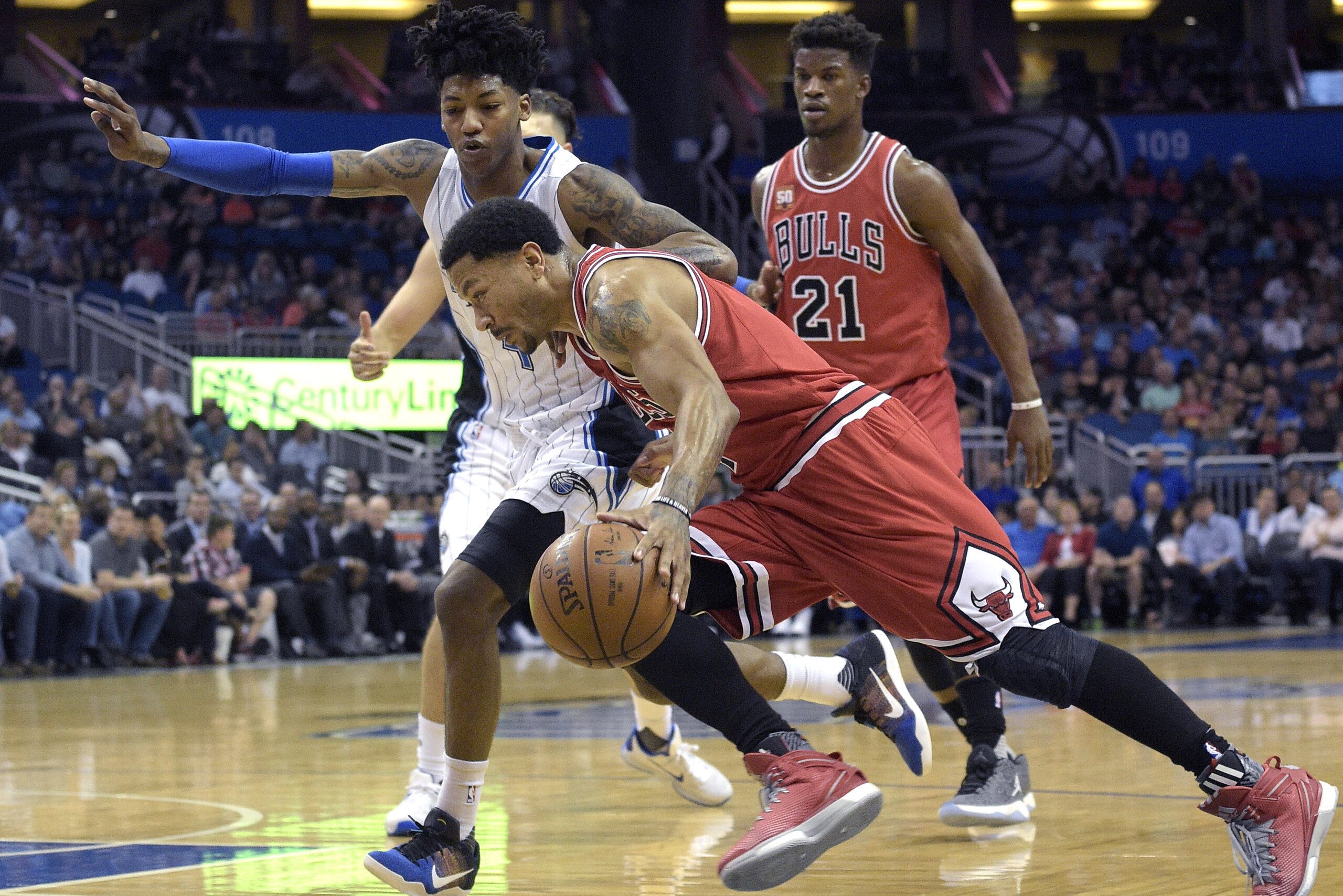 Chicago Bulls guard Derrick Rose (1) drives past Orlando Magic guard Elfrid Payton (4) as Bulls guard Jimmy Butler (21) watches during the first half of an NBA basketball game in Orlando, Fla., Saturday, March 26, 2016. (AP Photo/Phelan M. Ebenhack)