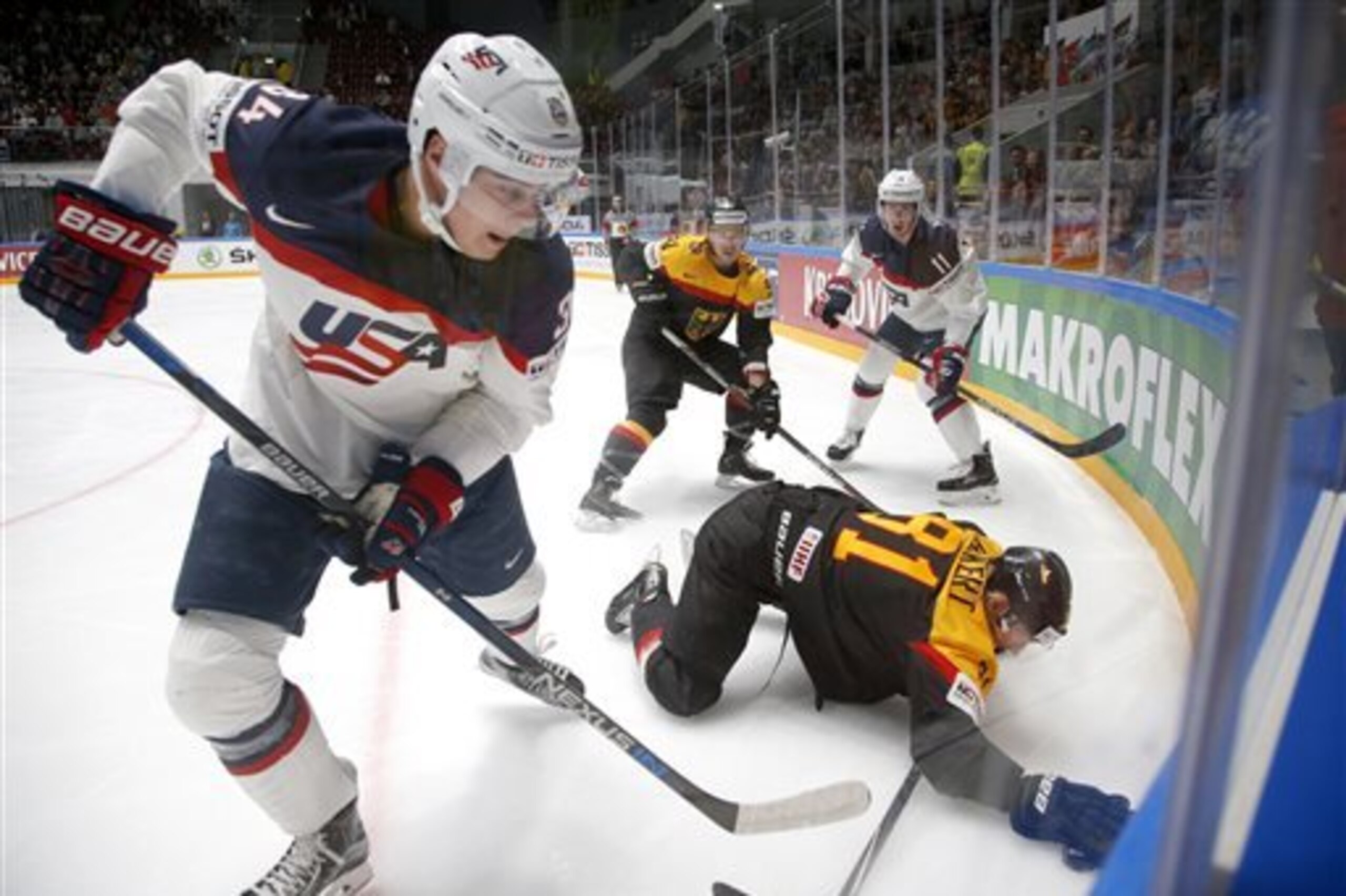 FILE - In this May 15, 2016 file photo, United States' Auston Matthews, left, fights for the puck with Germany’s Torsten Ankert during a Hockey World Championships Group B match in St.Petersburg, Russia.  About a year before Matthews was born in Arizona, professional hockey descended on the desert. Learning to skate might never be a top-of-the-bucket-list item for the youth of the American Southwest, with a prohibitive climate and a scant tradition, but hockey has been on the rise in the Phoenix area since the franchise relocated from Winnipeg in 1996. The embodiment of the sport’s expansion, though, will be on stage Saturday, June  25, 2016at the NHL draft. Matthews is expected to be the first pick.  (AP Photo/Dmitri Lovetsky, File)