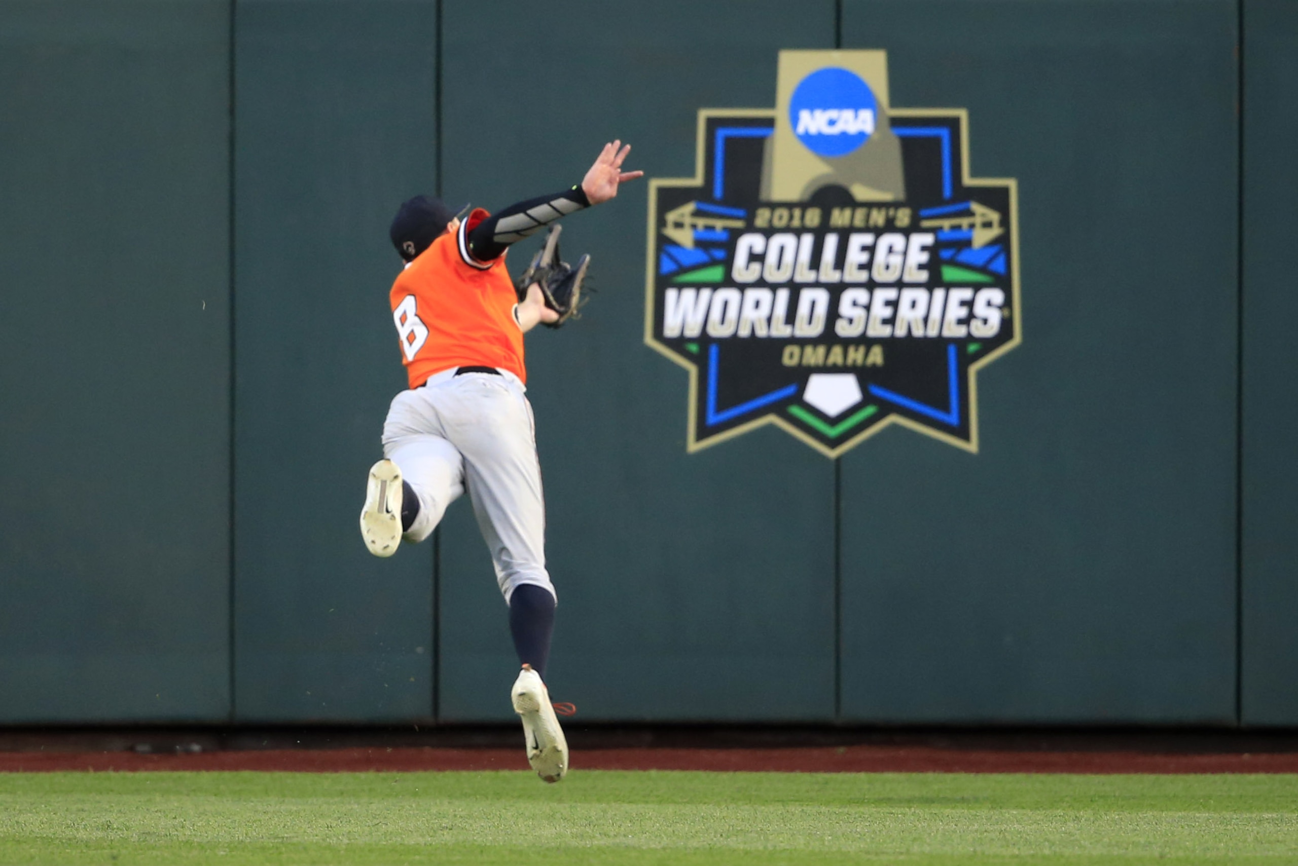 Oklahoma State center fielder Ryan Sluder dives to catch a ball hit by Arizona's Cody Ramer for an out during the first inning of an NCAA College World Series baseball game, Monday, June 20, 2016, in Omaha, Neb. (AP Photo/Nati Harnik)