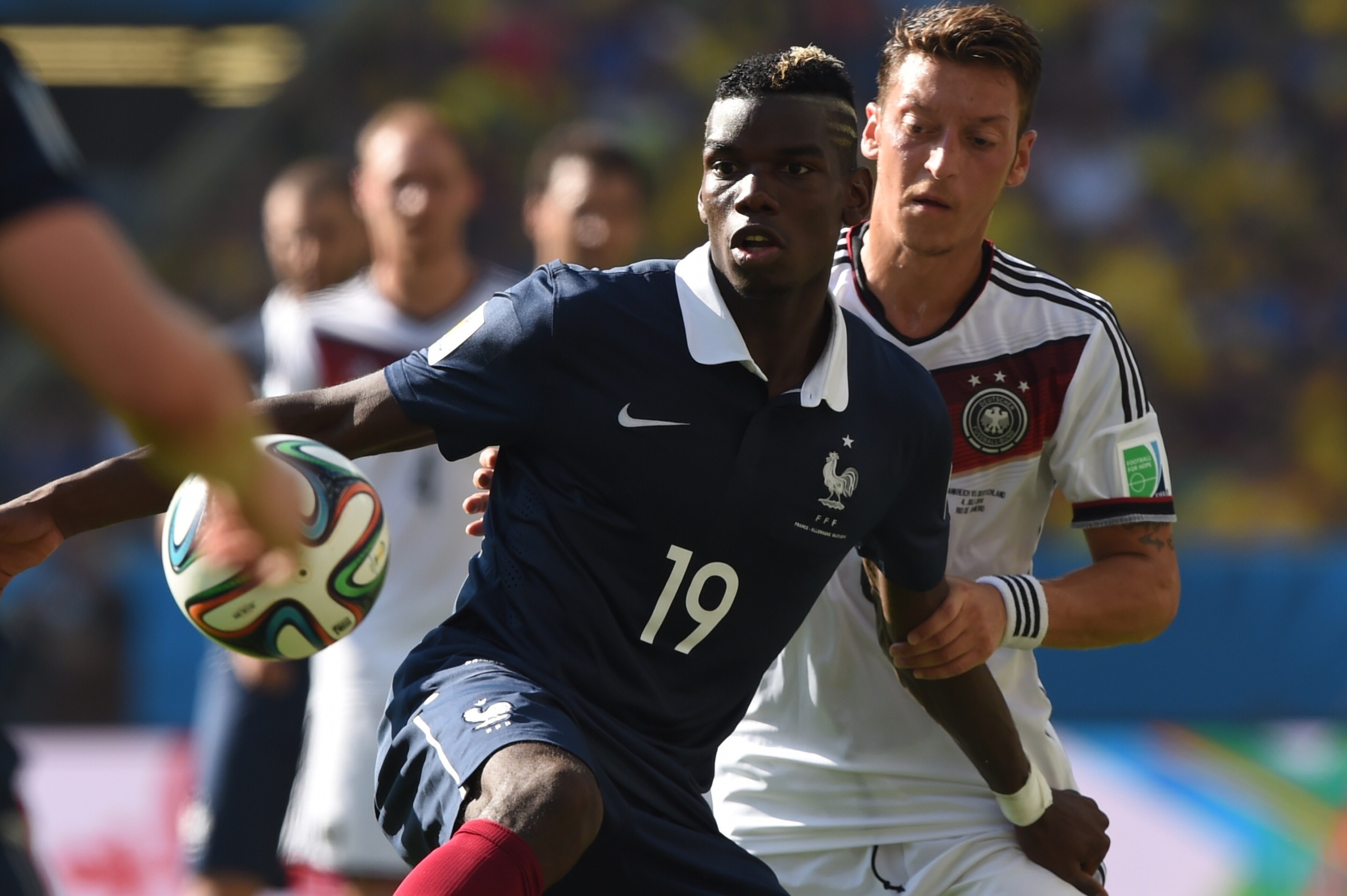 France's midfielder Paul Pogba (L) and Germany's midfielder Mesut Ozil vie for the ball during the quarter-final football match between France and Germany at the Maracana Stadium in Rio de Janeiro during the 2014 FIFA World Cup on July 4, 2014.  AFP PHOTO / PEDRO UGARTE        (Photo credit should read PEDRO UGARTE/AFP/Getty Images)