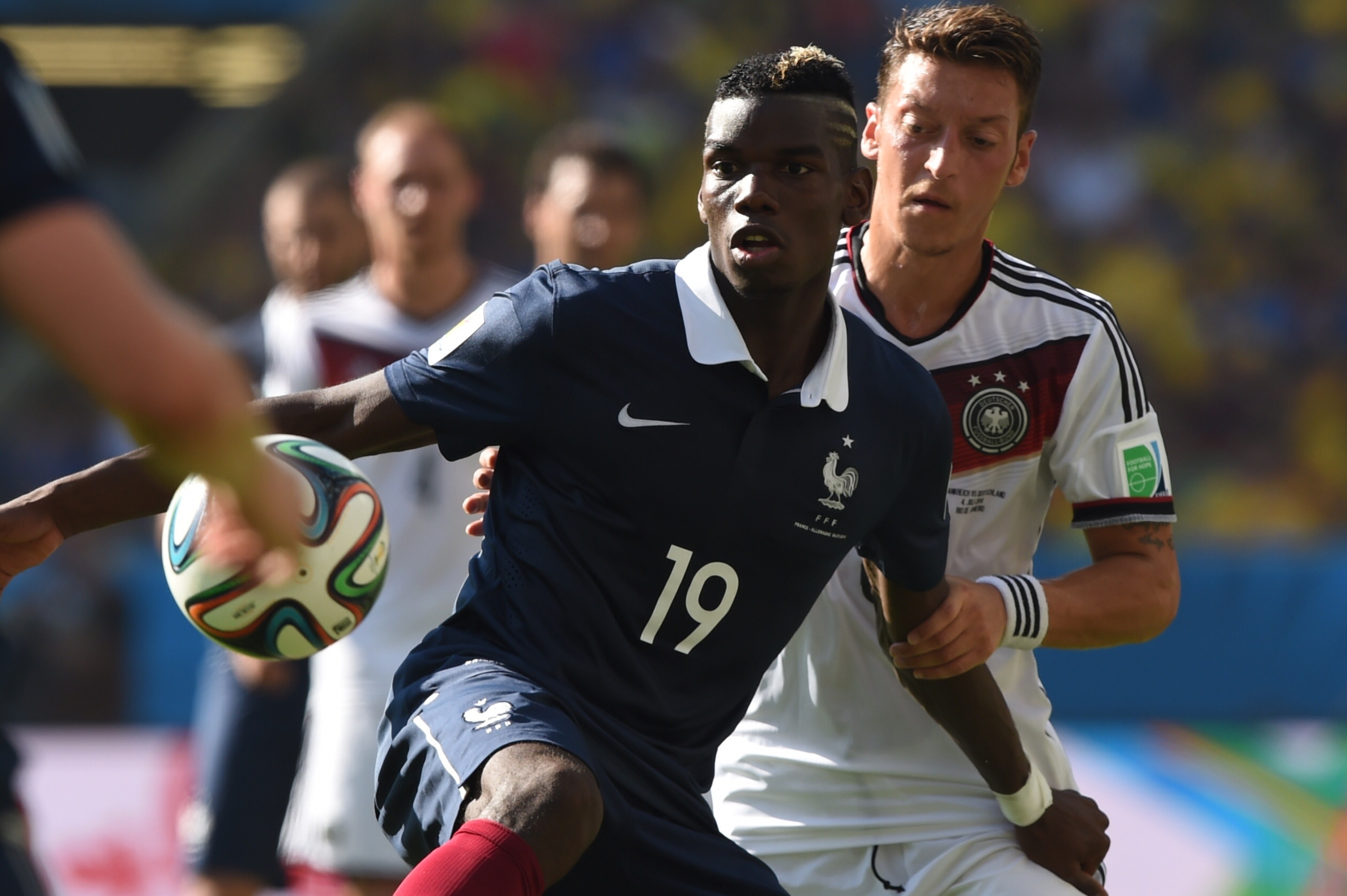 France's midfielder Paul Pogba (L) and Germany's midfielder Mesut Ozil vie for the ball during the quarter-final football match between France and Germany at the Maracana Stadium in Rio de Janeiro during the 2014 FIFA World Cup on July 4, 2014.  AFP PHOTO / PEDRO UGARTE        (Photo credit should read PEDRO UGARTE/AFP/Getty Images)