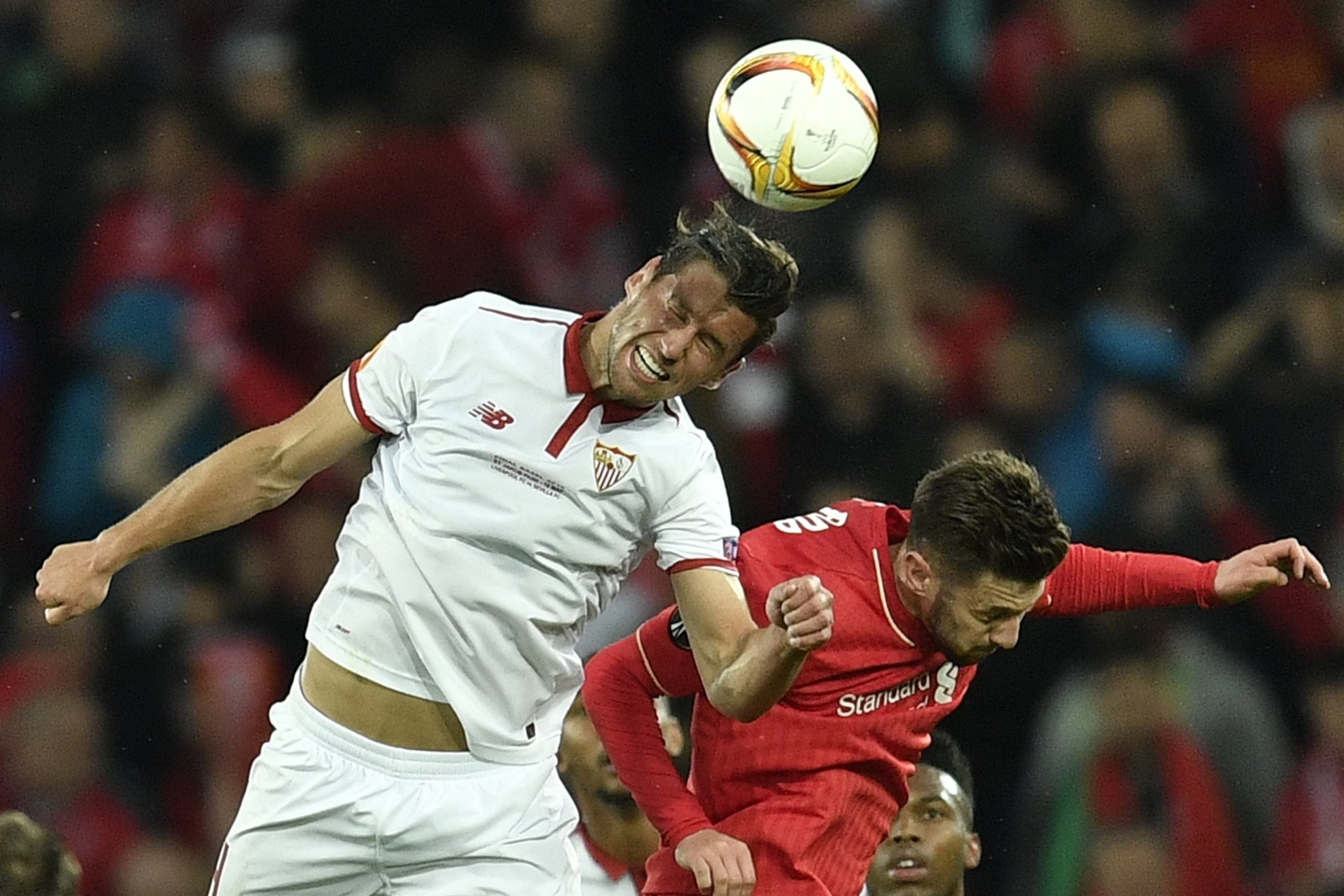 Sevilla's Grzegorz Krychowiak, left, is challenged by Liverpool's Adam Lallana during the Europa League final between Liverpool FC and Sevilla FC in Basel, Switzerland, Wednesday, May 18, 2016. (AP Photo/Martin Meissner)