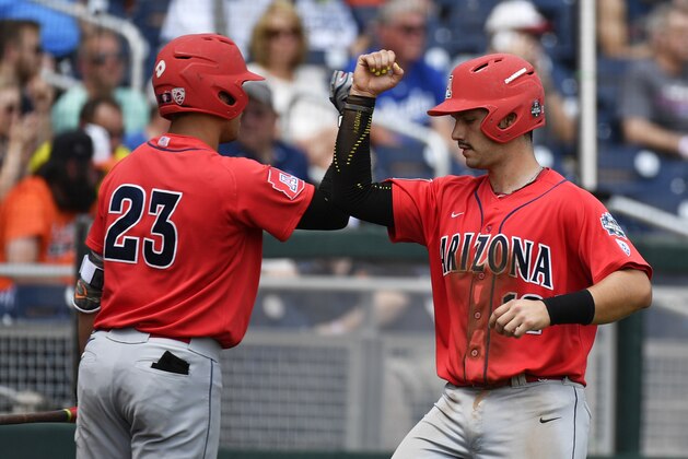Arizona's Zach Gibbons (23) celebrates with teammate Cesar Salazar, right, after Salazar scored against Oklahoma State in the second inning of an NCAA men's College World Series baseball game, Friday, June 24, 2016, in Omaha, Neb. (AP Photo/Ted Kirk)