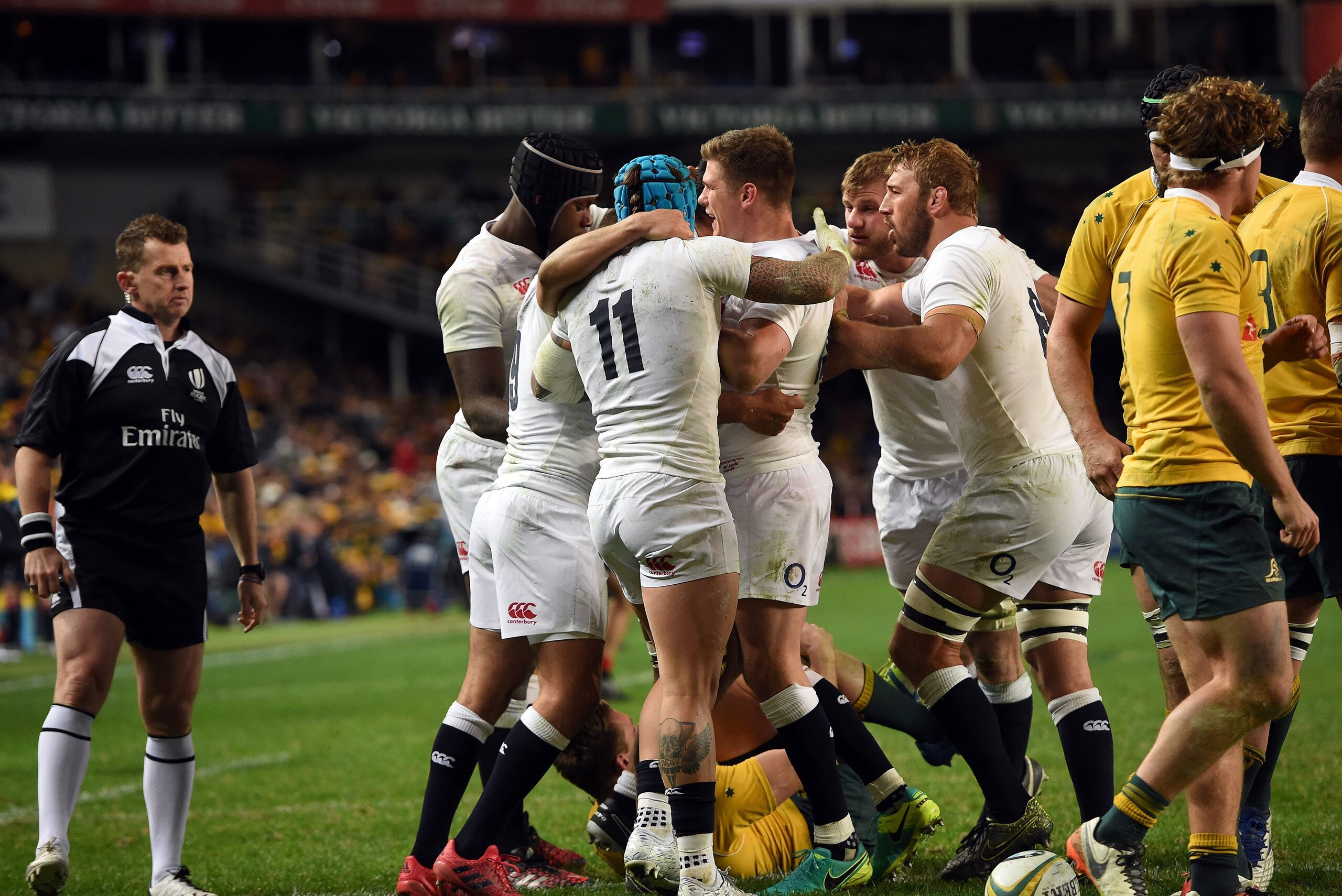 England (in white) celebrates a successful try against Australia (in yellow) during their third and final rugby union Test in Sydney on June 25, 2016. / AFP / SAEED KHAN / --IMAGE RESTRICTED TO EDITORIAL USE - STRICTLY NO COMMERCIAL USE--        (Photo credit should read SAEED KHAN/AFP/Getty Images)