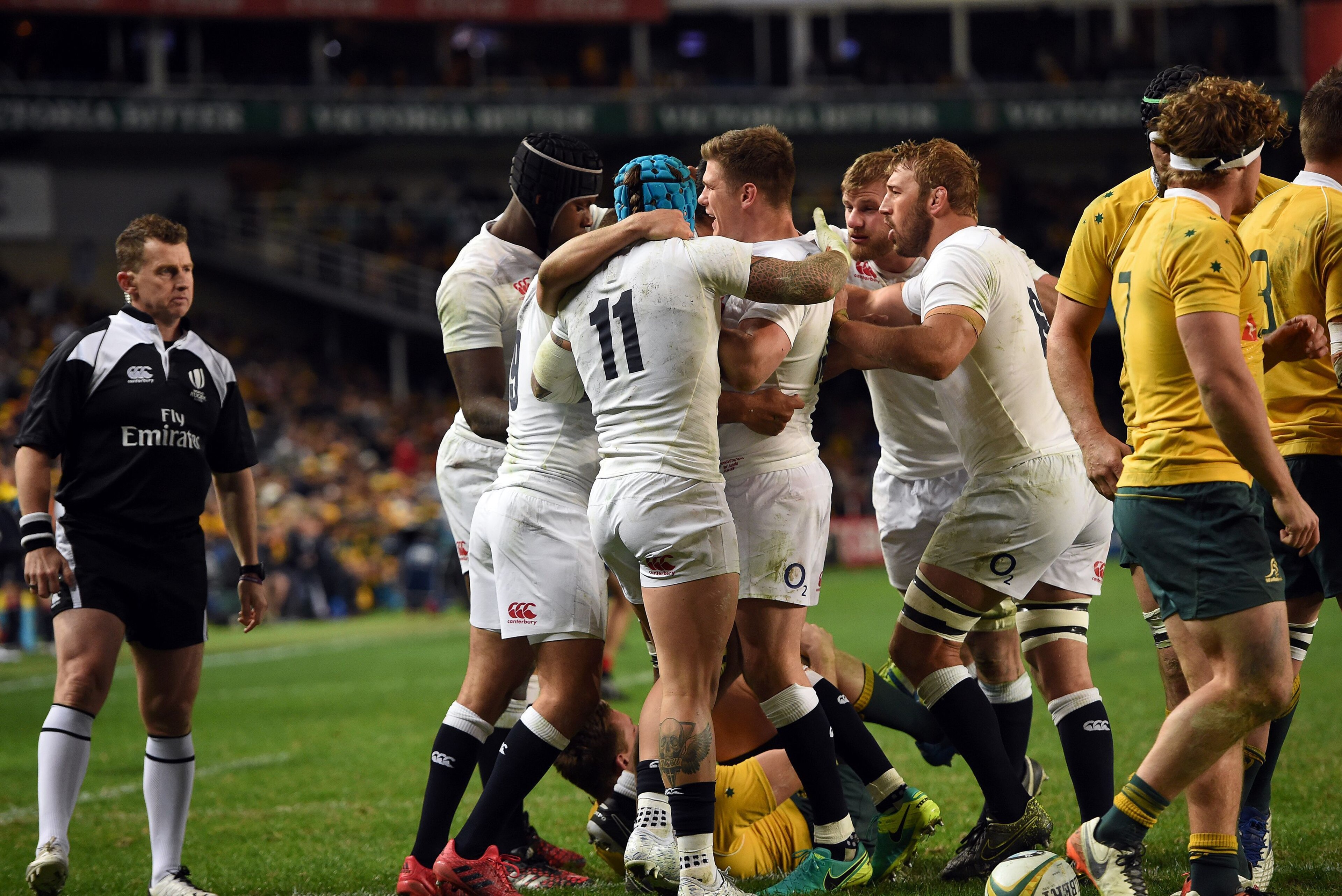 England (in white) celebrates a successful try against Australia (in yellow) during their third and final rugby union Test in Sydney on June 25, 2016. / AFP / SAEED KHAN / --IMAGE RESTRICTED TO EDITORIAL USE - STRICTLY NO COMMERCIAL USE--        (Photo credit should read SAEED KHAN/AFP/Getty Images)