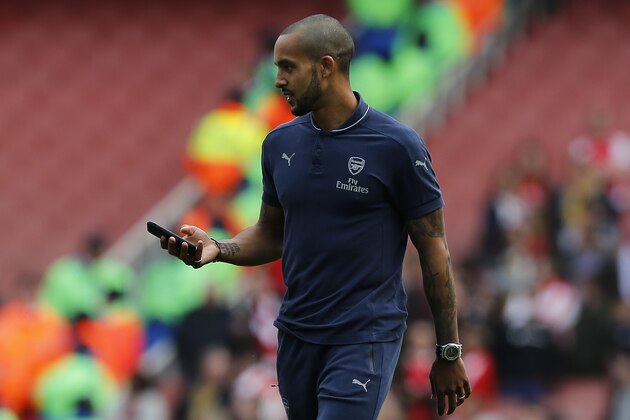 Arsenal's English midfielder Theo Walcott carrys a mobile phone as he walks around the pitch following the English Premier League football match between Arsenal and Aston Villa at the Emirates Stadium in London on May 15, 2016.  / AFP / Ian Kington / RESTRICTED TO EDITORIAL USE. No use with unauthorized audio, video, data, fixture lists, club/league logos or 'live' services. Online in-match use limited to 75 images, no video emulation. No use in betting, games or single club/league/player publications.  /         (Photo credit should read IAN KINGTON/AFP/Getty Images)