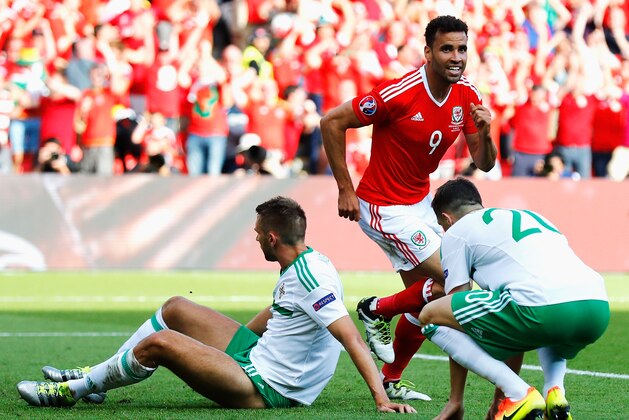 PARIS, FRANCE - JUNE 25:  Hal Robson-Kanu (C) of Wales celebrates his team's first goal while Gareth McAuley (L) of Northern Ireland shows his dejection during the UEFA EURO 2016 round of 16 match between Wales and Northern Ireland at Parc des Princes on June 25, 2016 in Paris, France.  (Photo by Clive Rose/Getty Images)