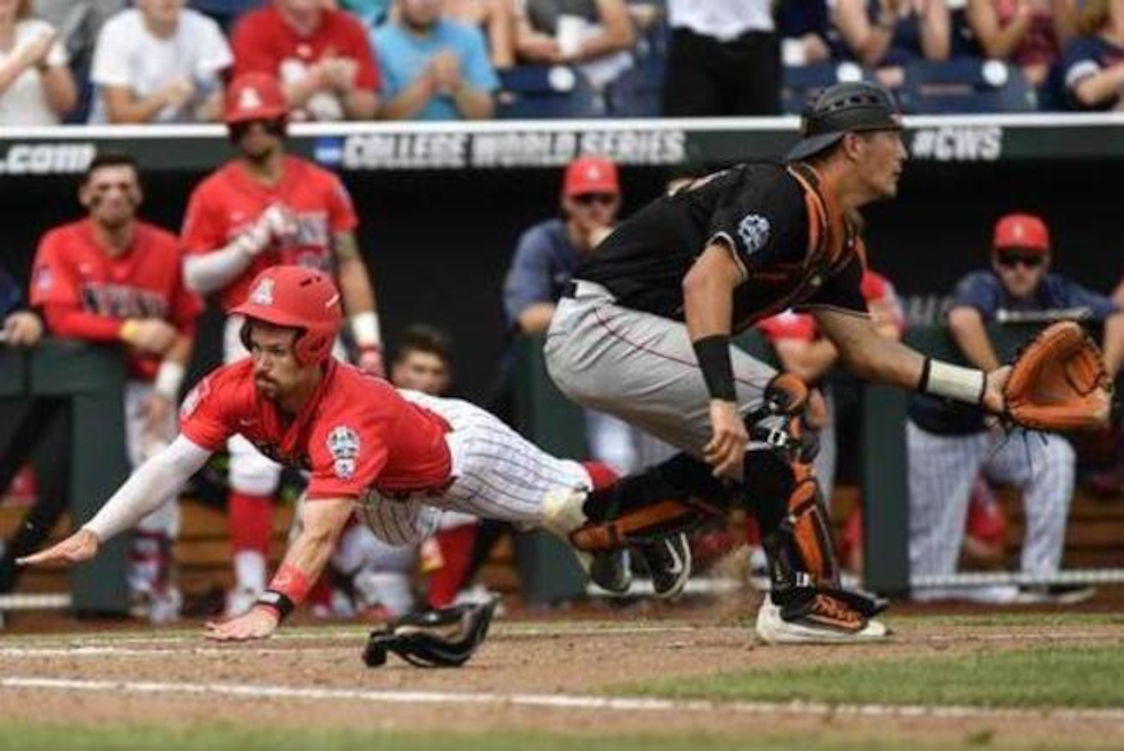 Arizona's Louis Boyd, left, dives safely into home plate to score on a double by Zach Gibbons as Oklahoma State catcher Collin Theroux, right, waits for the ball during the fourth inning of an NCAA men's College World Series baseball game in Omaha, Neb., Saturday, June 25, 2016. (AP Photo/Ted Kirk)