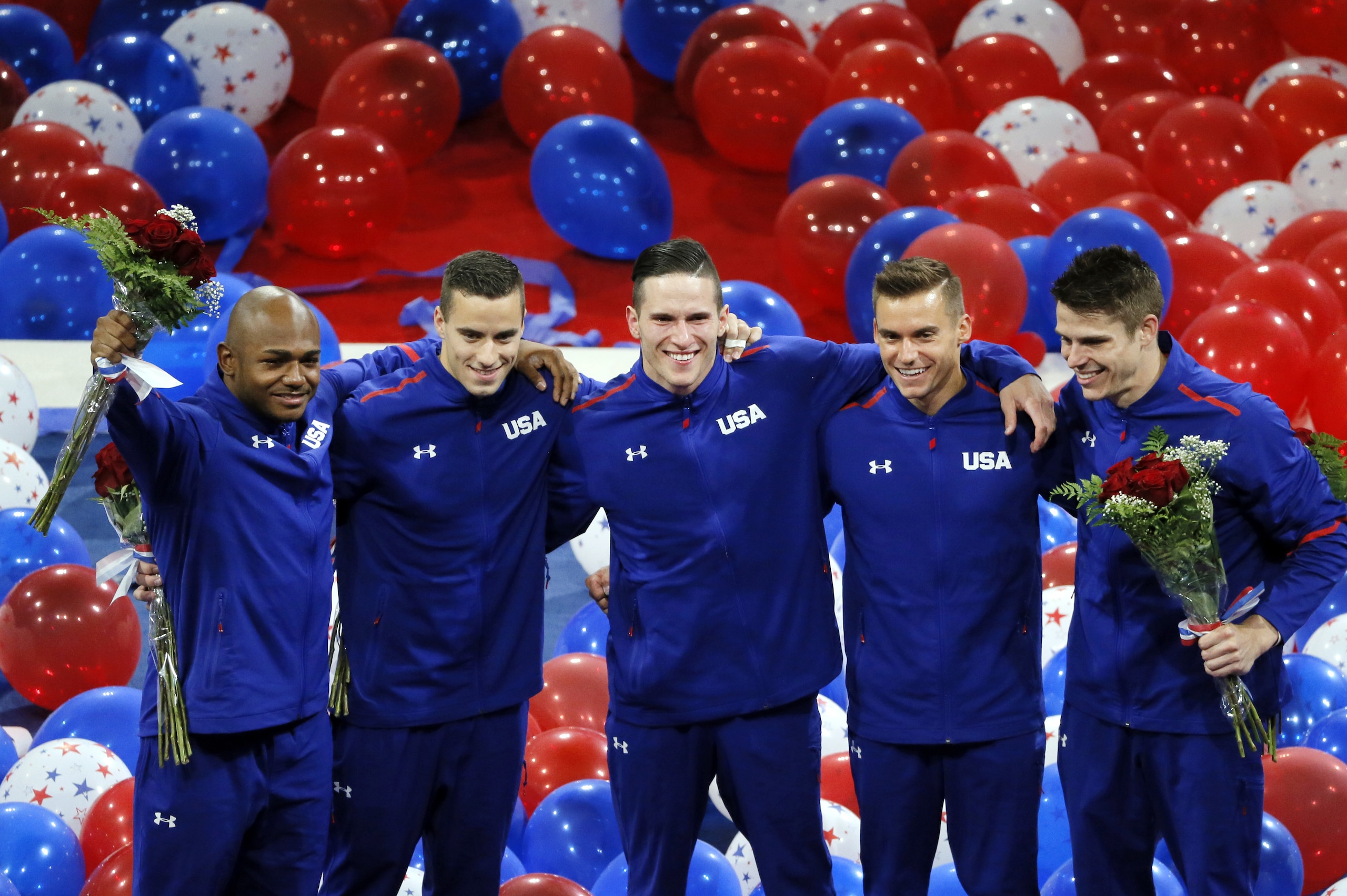 Sam Mikulak, from left, Alex Naddour, Chris Brooks, Jacob Dalton and John Orozco, right, acknowledge cheers from fans after being introduced as the U.S. men's Olympic gymnastics team, Saturday, June 25, 2016, in St. Louis. (AP Photo/Tony Gutierrez)