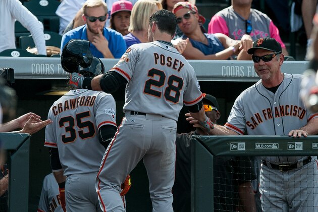 DENVER, CO - SEPTEMBER 6:   Buster Posey #28 of the San Francisco Giants celebrates with manager Bruce Bochy #15 after hitting a fourth inning solo home run for the 100th of his career against the Colorado Rockies during a game at Coors Field on September 6, 2015 in Denver, Colorado.  (Photo by Dustin Bradford/Getty Images)