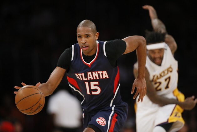 Atlanta Hawks' Al Horford dribbles the ball as Los Angeles Lakers' Jordan Hill chases down court during the first half of an NBA Basketball game, Sunday, March 15, 2015, in Los Angeles. (AP Photo/Danny Moloshok)