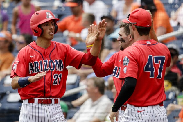 Arizona's Ryan Aguilar (21) celebrates with teammates after scoring on a sacrifice fly by Jared Oliva during the first inning of an NCAA men's College World Series baseball game against Oklahoma State in Omaha, Neb., Saturday, June 25, 2016. (AP Photo/Nati Harnik)