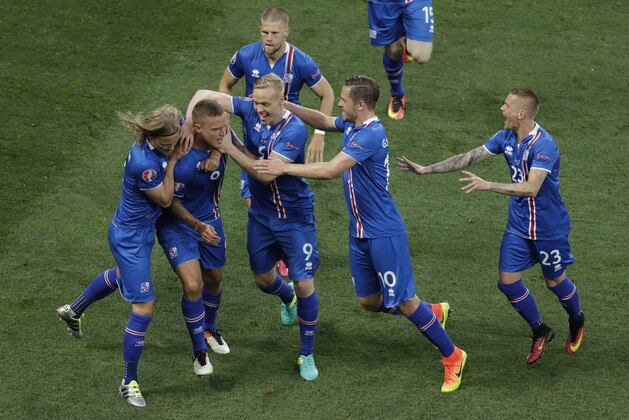 Iceland players celebrate after their teammate Ragnar Sigurdsson, second from left, scored during the Euro 2016 round of 16 soccer match between England and Iceland, at the Allianz Riviera stadium in Nice, France, Monday, June 27, 2016. (AP Photo/Ariel Schalit)