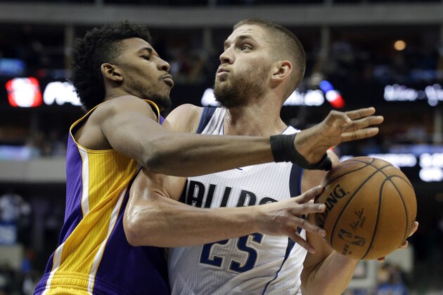 Los Angeles Lakers' Nick Young (0) defends as Dallas Mavericks' Chandler Parsons (25) attempts to reach the basket for a shot in the second half of an NBA basketball game, Friday, Nov. 21, 2014, in Dallas. The Mavericks won 140-106. (AP Photo/Tony Gutierrez)