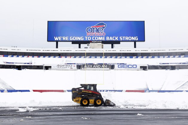 Workers clear snow from the field at Ralph Wilson Stadium on Sunday, Nov. 23, 2014, in Orchard Park, N.Y. Snowed out today at the stadium, the Bills are in Detroit to play their