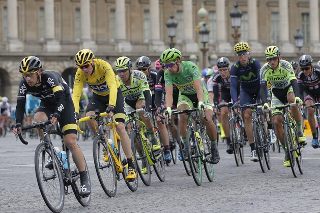 The pack with Britain's Chris Froome, wearing the overall leader's yellow jersey, and Peter Sagan of Slovakia, wearing the best sprinter's green jersey, exit Rue de Rivoli during the twenty-first and last stage of the Tour de France cycling race over 109.5 kilometers (68 miles) with start in Sevres and finish in Paris, France, Sunday, July 26, 2015. (AP Photo/Christophe Ena)