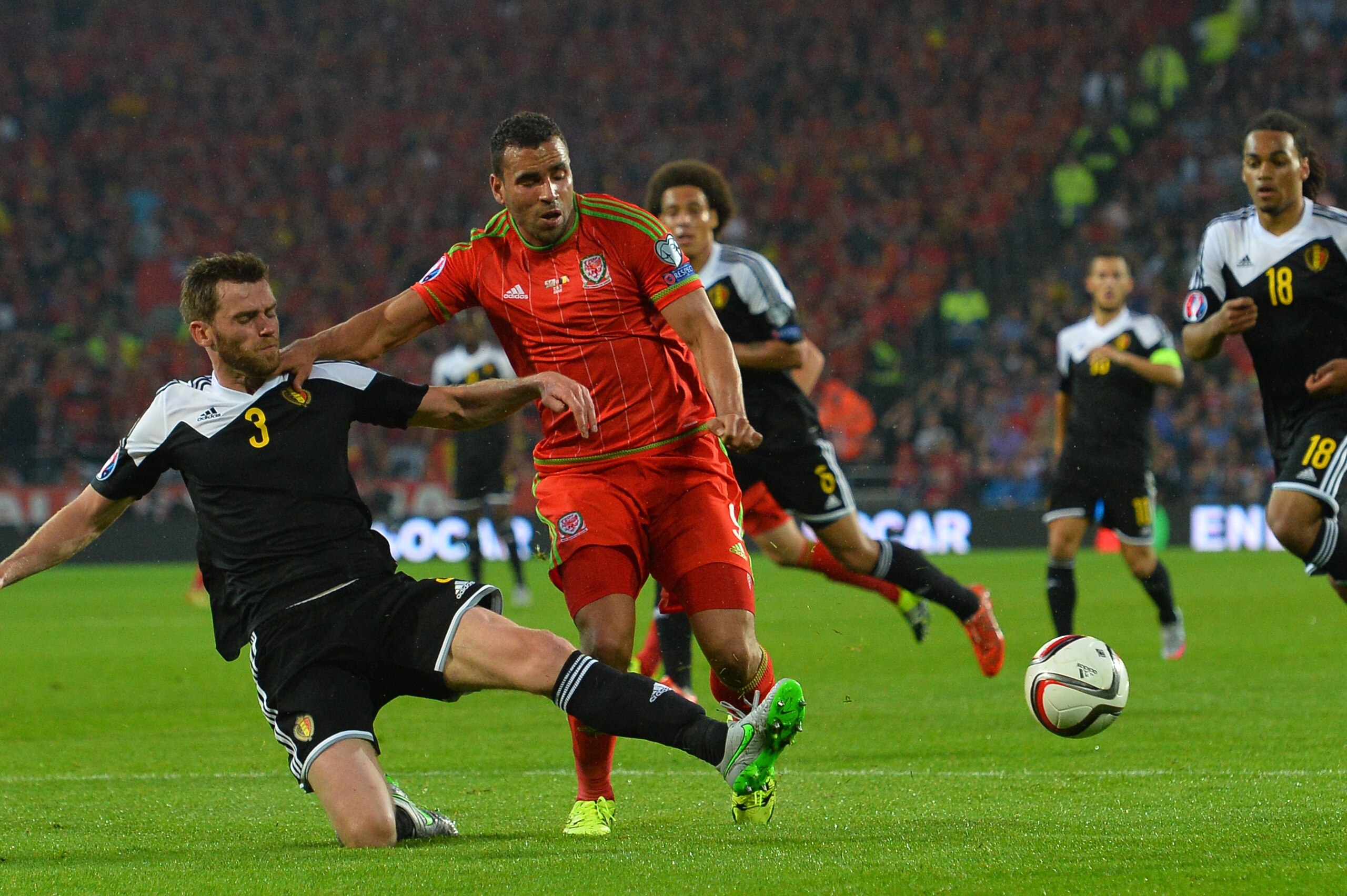 Wales's midfielder Hal Robson-Kanu (2L) is tackled by Belgium's defender Nicolas Lombaerts (L) during the Euro 2016 qualifying group B football match between Wales and Belgium at Cardiff City Stadium in Cardiff, south Wales, on June 12, 2015. Wales held on to a 1-0 lead given to them by the first half strike of Gareth Bale to win the match and go top of group B.  AFP PHOTO / GLYN KIRK        (Photo credit should read GLYN KIRK/AFP/Getty Images)