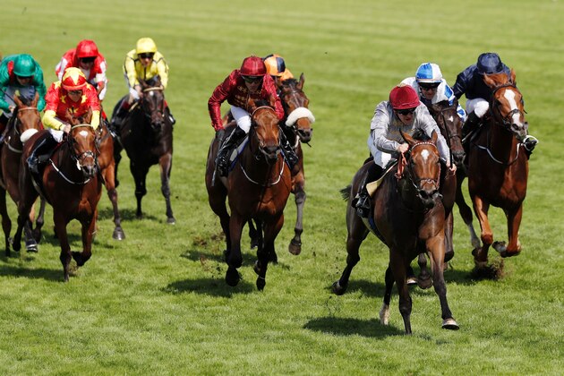 Jockey Gregory Benoist (3rd R) rides Qemah to victory to win The Coronation Stakes group 1 race during day four at Royal Ascot horse racing meet, in Ascot, west of London, on June 17, 2016. 
The five-day meeting is one of the highlights of the horse racing calendar. Horse racing has been held at the famous Berkshire course since 1711 and tradition is a hallmark of the meeting. Top hats and tails remain compulsory in parts of the course while a daily procession of horse-drawn carriages brings the Queen to the course.  / AFP / ADRIAN DENNIS        (Photo credit should read ADRIAN DENNIS/AFP/Getty Images)