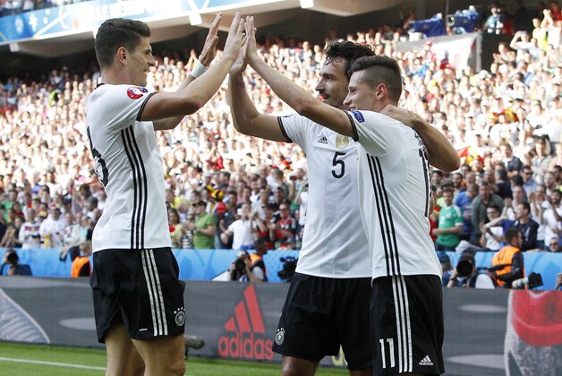 Germany's Julian Draxler, right, celebrates with his teammates Mats Hummels, center, and Mario Gomez after scoring during the Euro 2016 round of 16 soccer match between Germany and Slovakia, at the Pierre Mauroy stadium in Villeneuve d'Ascq, near Lille, France, Sunday, June 26, 2016. (AP Photo/ Michel Spingler)