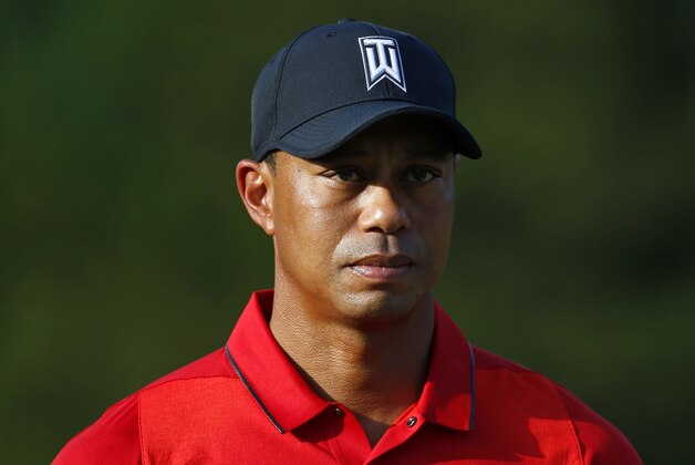 Tiger Woods stands on the 18th green during a trophy ceremony for Quicken Loans National PGA golf tournament winner Billy Hurley III, Sunday, June 26, 2016, in Bethesda, Md. (AP Photo/Patrick Semansky)