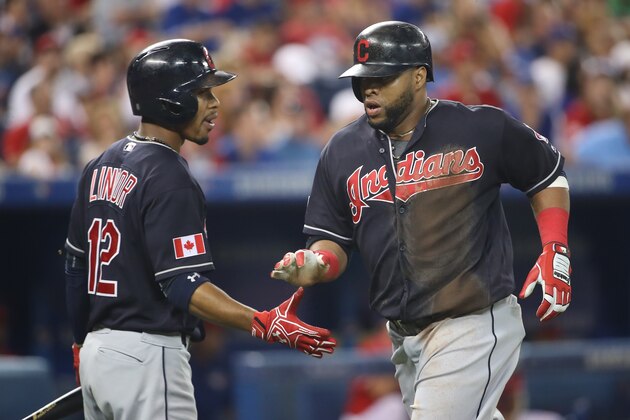 TORONTO, CANADA - JULY 1: Carlos Santana #41 of the Cleveland Indians is congratulated by Francisco Lindor #12 after scoring a run in the third inning during MLB game action against the Toronto Blue Jays on July 1, 2016 at Rogers Centre in Toronto, Ontario, Canada. (Photo by Tom Szczerbowski/Getty Images)