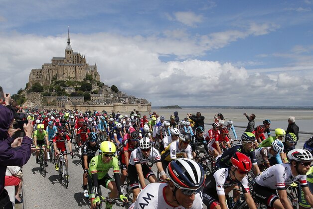 The pack with Germany’s Emanuel Buchmann, front row second left, and Netherlands' Laurens ten Dam, front row second right, takes the start at the Mont-Saint-Michel, rear, during the first stage of the Tour de France cycling race over 188 kilometers (116.8 miles) with start in Mont-Saint-Michel and finish in Utah Beach, France, Saturday, July 2, 2016. (AP Photo/Christophe Ena)