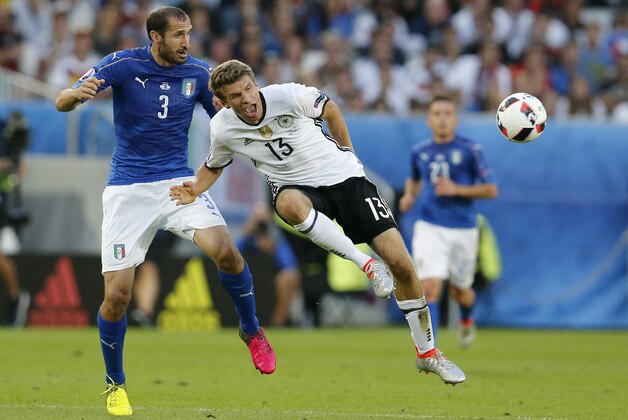 Italy's Giorgio Chiellini, left, and Germany's Thomas Mueller challenge for the ball during the Euro 2016 quarterfinal soccer match between Germany and Italy, at the Nouveau Stade in Bordeaux, France, Saturday, July 2, 2016. (AP Photo/Michael Probst)