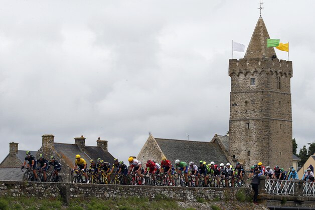 The pack with Britain's Mark Cavendish wearing the overall leader's yellow jersey  rides on a bridge during the second stage of the Tour de France cycling race over 183 kilometers (113.7 miles) with start in Saint-Lo and finish in Cherbourg-en-Cotentin, France, Sunday, July 3, 2016. (AP Photo/Peter Dejong)